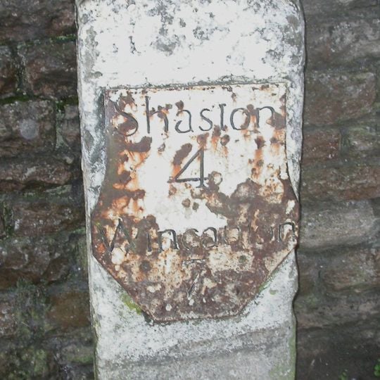 Milestone, by railway bridge