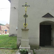Kříž u vchodu do kostela Nanebezvetí Panny Marie v Novém Rychnově