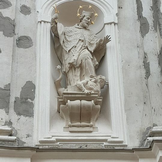 Socha svatého Jana Nepomuckého v nice vlevo na průčelí kostela svatých Janů v Minoritské ulici v Brně