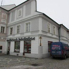 Kříž na domě Mléčných lahůdek čp.27 na Masarykově náměstí v Pelhřimově