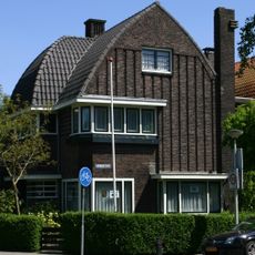 Vrijstaande villa, een samenhangend ensemble in baksteen, in Amsterdamse Schoolstij