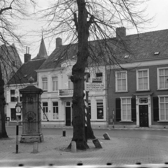 Herenhuis uit de eerste helft van de 19e eeuw, met dwars zadeldak en lijstgevel, ingang met versierd bovenlicht, hoofdgestel met guirlande en voluutvormige consoles