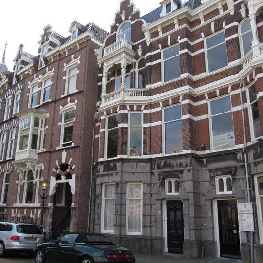 Pand in neo-renaissance trant. Parterre bekleed met hardsteen. Links een driezijdig uitgebouwde erker over twee verdiepingen, waarboven loggia van hout met rijk snijwerk. Topgevel