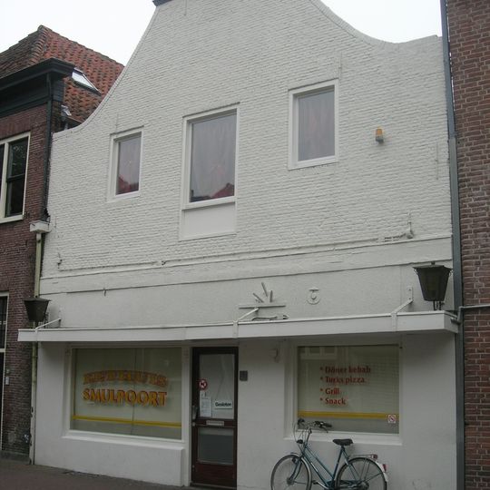 Huis met lijstgevel afgeknot. Uitgevoerd in baksteen met houten afdekking