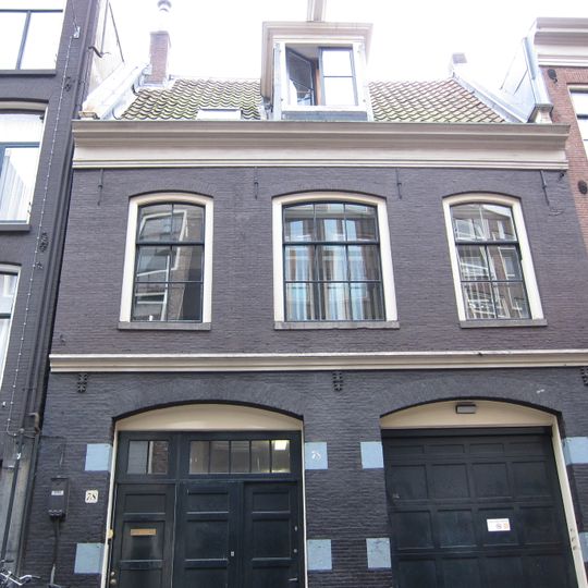 Voormalig koetshuis met gevel onder rechte lijst waarboven een dwars dak