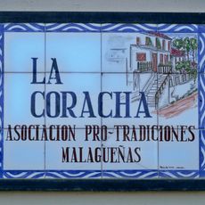 El mosaico incluye una imagen restrospectiva de cómo era la única casa que se conserva del antiguo barrio de La Coracha, donde se encuentra el mosaico. Sirve además de letrero de la sede de la asociación Pro-Tradiciones Malagueñas La Coracha.