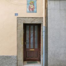 Porta i majòlica d'una casa al carrer de les Vinyes