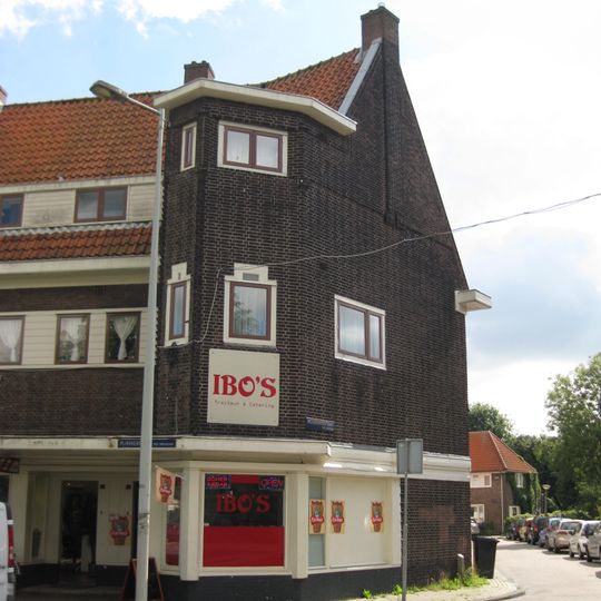 Blok met winkels met brede luifel en daarboven woningen, bouwstijl Amsterdamse School, onderdeel van het centrale achthoekige plein van Tuindorp Nieuwendam