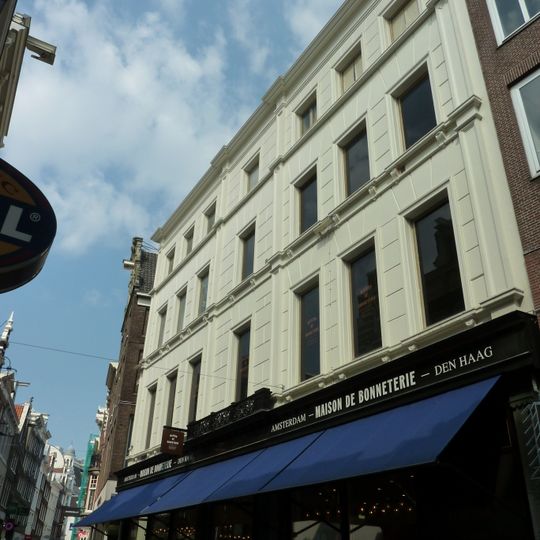 Pand met gevel onder bijzondere, grote zandstenen top in de vorm van een halsgevel met gedeelde vleugelstukken, volutenafdekking en ornament om het zoldervenster