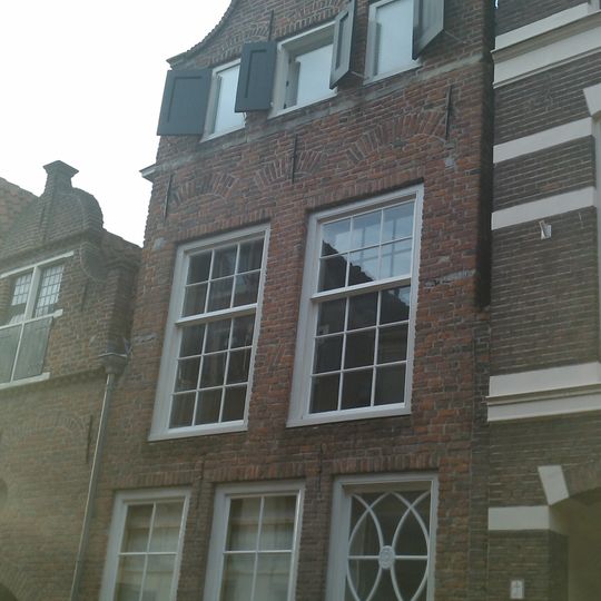 Onderkelderd huis met door eensteens rollaag gedekte klokgevel