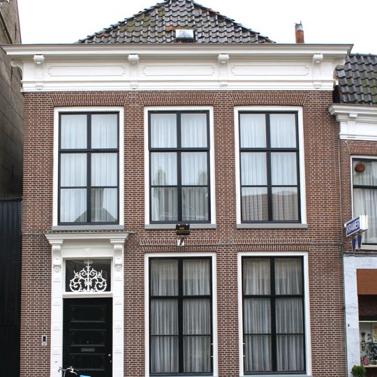 Woonhuis met verdieping en rechte rechte kroonlijst met consoles en versierd bovenlicht