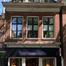 Pand met rechte kroonlijst onder schilddak met voorschild met dakkapel en schoorsteen