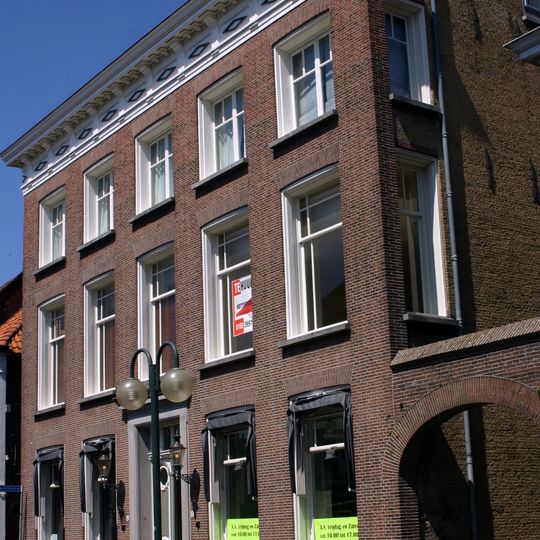 Herenhuis met dwars schilddak met kroonlijst met triglyphen en klossen; hardstenen ingangspartij. Lange achtervleugel aan de Kuipersstraat, ten dele met getraliede spitsboogvensters