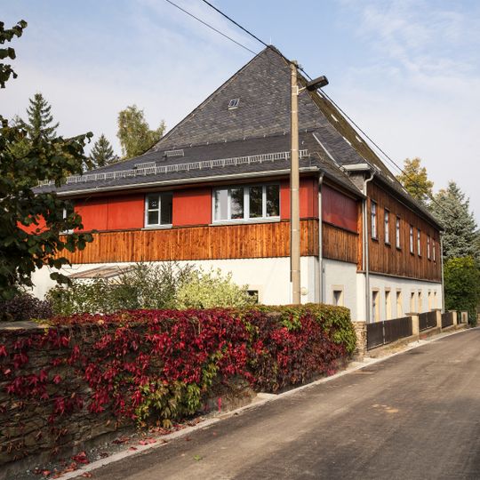 Pfarrhaus und Seitengebäude mit Einfriedungsmauer entlang des Kirchweges Kirchweg 4