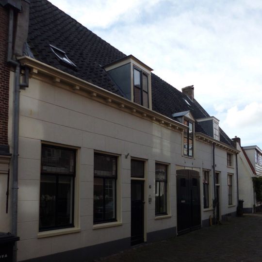 Huis met gepleisterde gevel en klossengoot