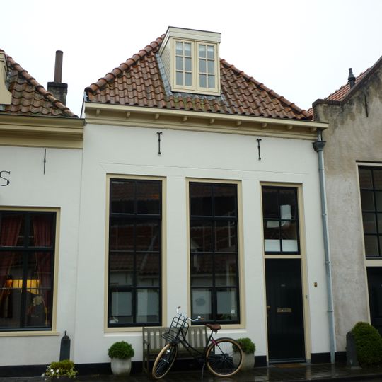 Pand met gepleisterde gevel en hoog schilddak