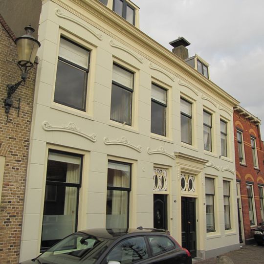 Herenhuis onder hoog zadeldak met schoorstenen