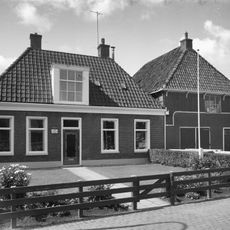 Eenvoudig breed pand onder schilddak met hoekschoorstenen