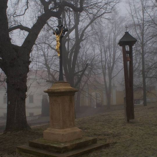 Boží muka a dřevěná zvonička na návsi před kostelem sv. Petra a Pavla v Peruci