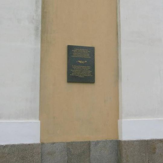 Pamětní deska Wenzela Karla vlevo na kostele v Království