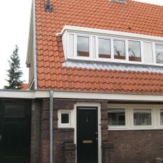 Blok met 8 keukenwoningen, zo genoemd vanwege destijds nieuwe plaatsing van keuken aan de voorzijde, aan de zijkant een houten topgevel, bouwstijl Amsterdamse School.