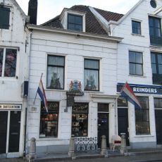 Kwakkelstein: winkel met bovenwoning, stoep, hek