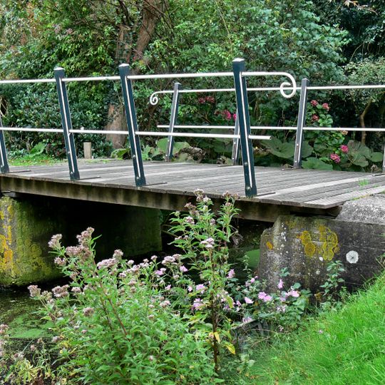 De brug over de wegsloot bestaat uit twee betonnen landhoofden die over de sloot met elkaar zijn verbonden door een samenstelsel van houten planken.