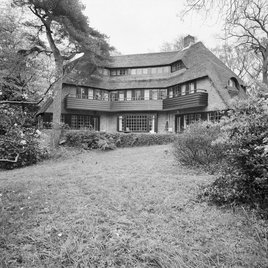 Villa met garage, tuinaanleg en toegangshek in expressionistische landhuistijl