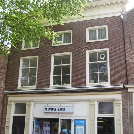 Pand met voorgevel met geblokte kroonlijst onder hoog schilddak met halfronde dakkapel en topschoorsteen