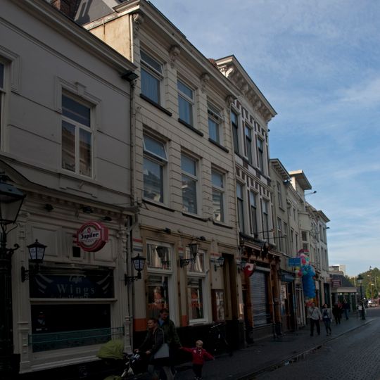 Huis met gebosseerd gepleisterde lijstgevel, nog geheel woonhuis