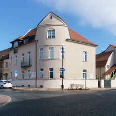 Wohnhaus in halboffener Bebauung und in Ecklage, mit Nebengebäude (Garagenflügel) im Hof und Einfriedung Marktstraße 1