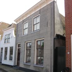 Pand met gepleisterde gevel met rechte kroonlijst