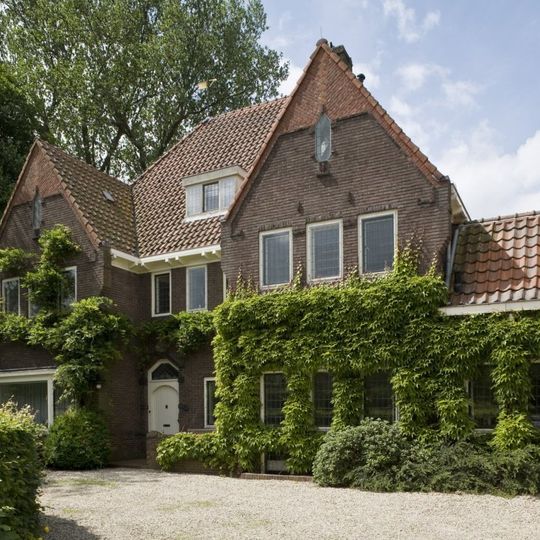 Villa met aangebouwde garage en gastenverblijf, in een aan de Delftse School verwante stijl