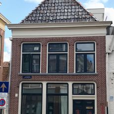 Hoekpand onder tentdak met twee door borden gedekte topschoorstenen