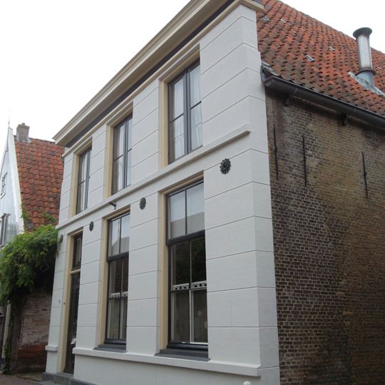 Huis met gepleisterde voorgevel en fraaie achtertopgevel boven een gepleisterde onderbouw
