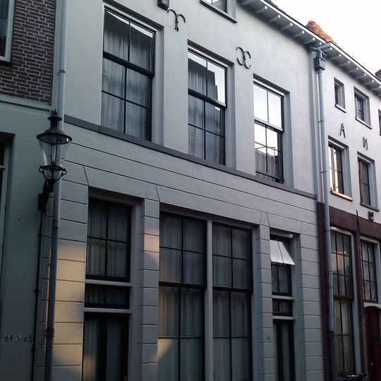 Onderkelderd pand met gedeeltelijk gepleisterde en geverfde rechte gevel