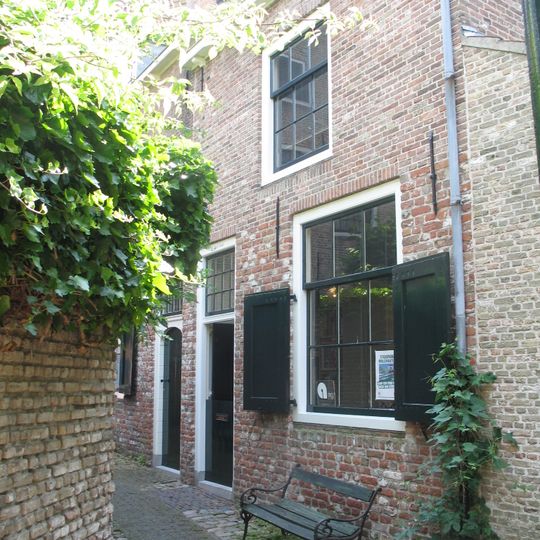 Dwarshuisje met gootlijst op klossen en gecementeerde gevel