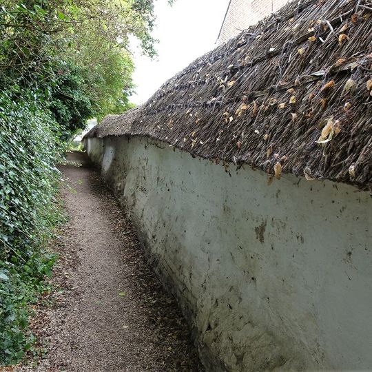Cob wall forming southern boundary to housing estate
