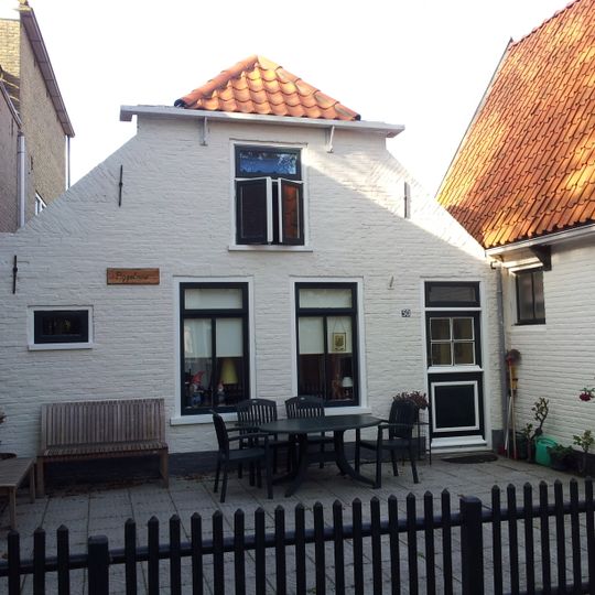 Pand met afgeknotte gevel van grijs geverfde steen