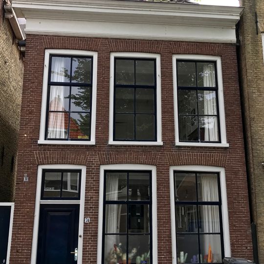 Woonhuis onder schilddak met topschoorsteen waarop bord