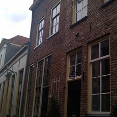 Hoog pand met zadeldak tussen puntgevels