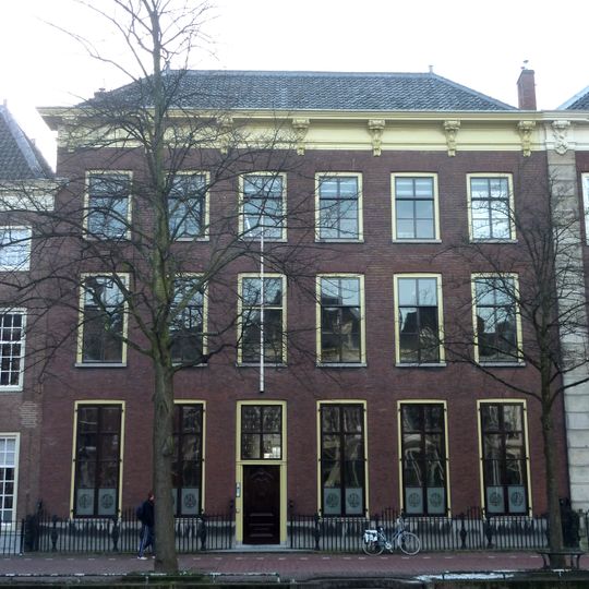 Pand met brede bakstenen gevel, rechte kroonlijst en gesnede consoles. Hardstenen stoep met fraai gesmeed ijzeren hek, gebeeldhouwde deur