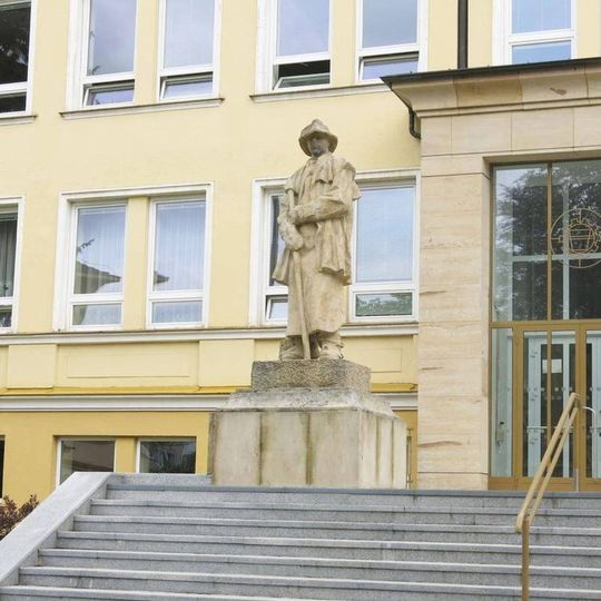Socha hutníka vlevo před průmyslovou školou v Studentské ulici v Žďáru nad Sázavou