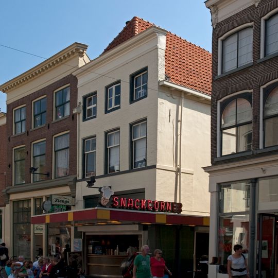 Pand met voor een rechte lijstgevel en jongere onderpui en achter een gepleisterde laatgotische trapgevel