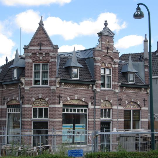 Pand met verdieping onder dwarsgeplaatst schilddak met aanbouw aan achterzijde onder schilddak