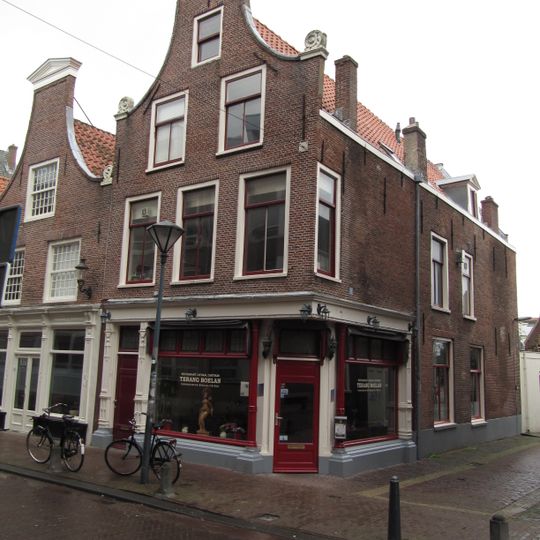 Pand met klokgevel, gebeeldhouwde natuurstenen voluten op de hoeken aan weerszijden