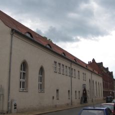 Einzeldenkmal der o. g. Sachgesamtheit: Ehemaliges Klostergebäude mit Klosterkapelle, Kellern, Resten des aufgehenden Mauerwerks und Durchfahrt und ehemaliges Rektoratsgebäude sowie überdachter Verbindungsbau, Zwischenbauten und Anbau aus den 1950