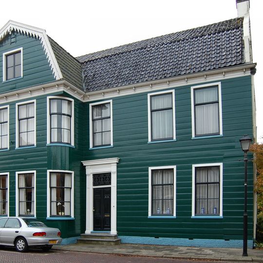 Groot houten huis op L-vormige plattegrond