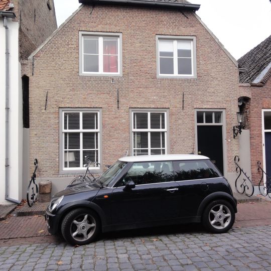 Huis met topgevel aan de voorzijde, zadeldak aan de achterzijde afgewolfd