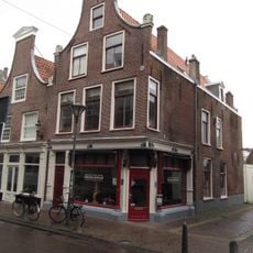 Pand met klokgevel, gebeeldhouwde natuurstenen voluten op de hoeken aan weerszijden